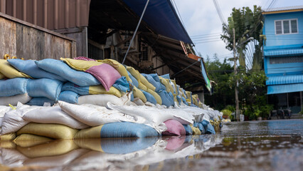 Many sandbags are stacked and reflected in the water.
