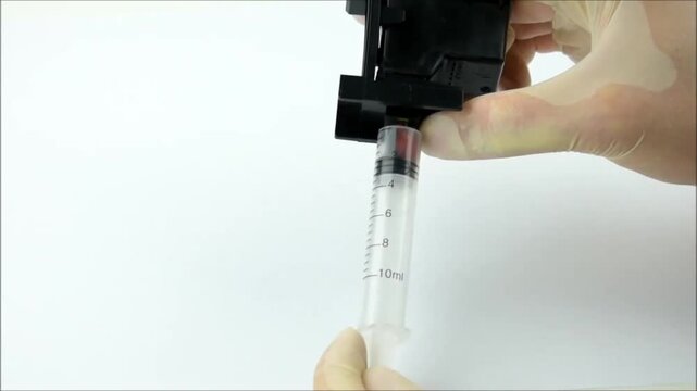 Syringe extracts leftover ink from an old cartridge in a clean, precise pull. Useful for refills, recycling, or salvaging usable ink from nearly empty printer tanks