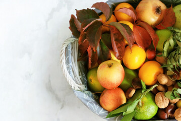 Abundant autumn harvest in a basket with colorful leaves