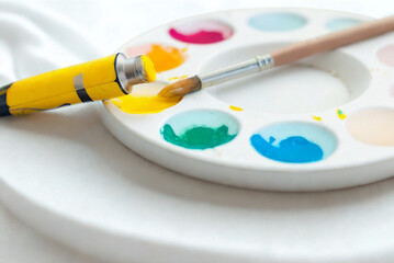 Obraz premium Artist s palette with yellow paint and brush