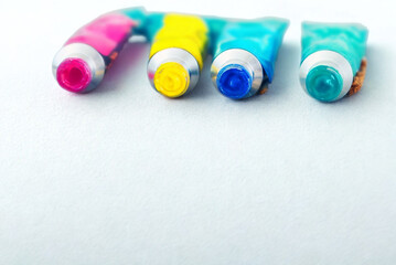 Colorful paint tubes lying down on a white surface