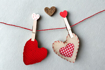 Two heart decorations hanging on a red string with clothespins