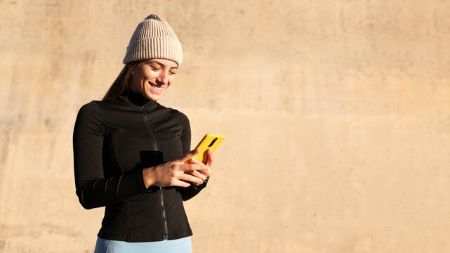Happy athlete woman checking smartphone after workout