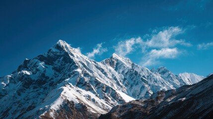 Fototapeta premium Snow covered peaks tower against a brilliant blue sky showcasing natures amazing beauty.