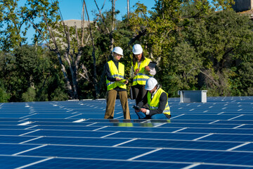 Engineers inspecting solar panels on a renewable energy farm