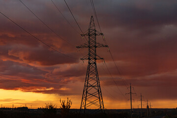 Fototapeta premium Electricity pylons at sunset. Electricity distribution station. Energy industry. 