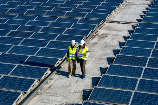 Engineers inspecting solar panels on rooftop solar farm