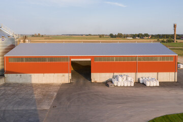 Modern Agricultural Warehouse in Rural Farm Landscape with Storage Bags Visible