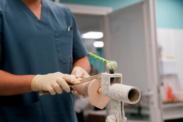 Experienced technician carefully shapes a prosthetic limb using a cutting instrument in a well-lit clinic. The focus is on ensuring a perfect fit, demonstrating attention to detail.