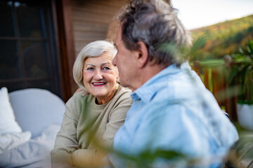 Fototapeta premium Peaceful moment for senior couple, enjoying warm autumn evening on terrace.