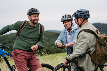 Grandfather, father and teen boy on cycling trip in nature.
