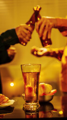 A group of friends toasting with beer glasses at a lively night gathering, surrounded by delicious fried chicken and snacks, symbolizing teamwork, celebration, friendship, joyful social connection.