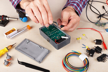 Hands serviceman repairing electrical devices at service workplace.