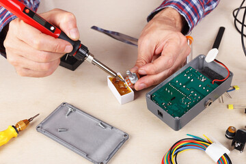 Soldering electrical board of device at service workplace.