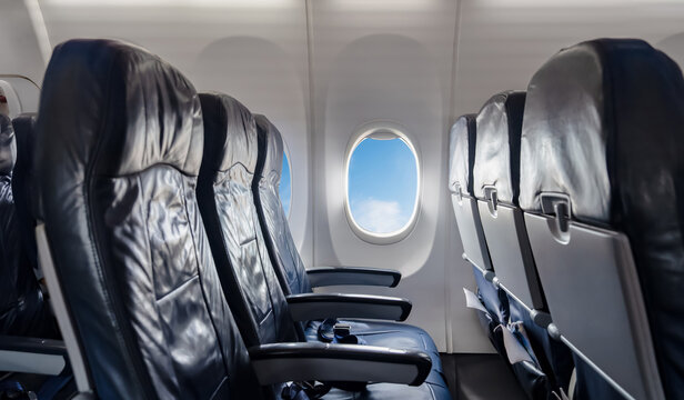 Empty airplane seats and windows with blue sky view during flight.inside plane for travel concepts,airline promotion,passenger experience,transportation ads,holiday vocation in flight services visuals