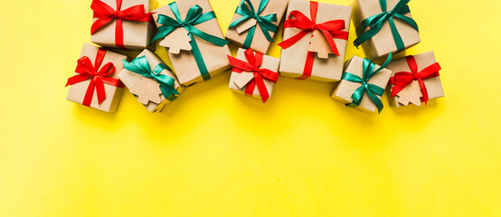 wrapped christmas or other holiday handmade present in paper with colored ribbon. Present box, decoration of gift on colourfull table, top view with copy space