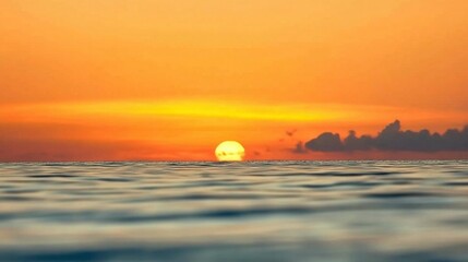 Breathtaking sunset spectacle paints the tranquil ocean horizon with warm orange and yellow hues