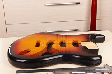 Body of electric guitar at workplace of guitar repairman.