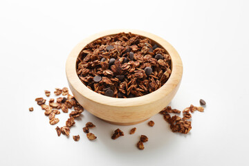 Delicious granola with chocolate chips in bowl on white background, closeup