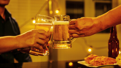 Close up friends hands clinking beer glasses in warm golden light, celebrating friendship teamwork. A joyful moment filled with laughter, unity, positive energy during relaxing evening gathering.