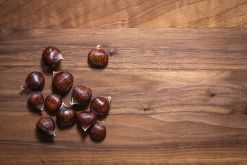 Top view of sweet chestnuts on walnut wooden board
