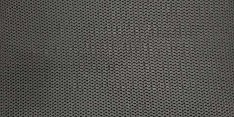 Detailed macro black mesh fabric typical material modern ergonomic office chairs. Textile features tight woven pattern small uniform openings creating perforated or honeycomb-like texture