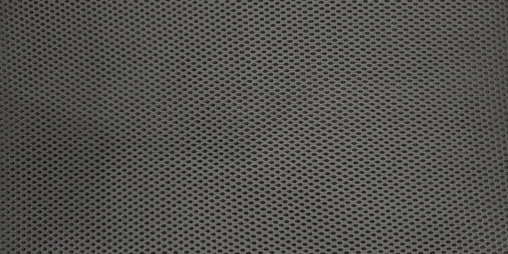 Detailed macro black mesh fabric typical material modern ergonomic office chairs. Textile features tight woven pattern small uniform openings creating perforated or honeycomb-like texture