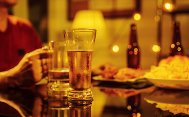 A group of friends toasting with beer glasses at a lively night gathering, surrounded by delicious fried chicken and snacks, symbolizing teamwork, celebration, friendship, joyful social connection.