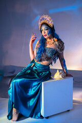 Attractive woman in a blue mermaid costume. Fantasy studio portrait of a mermaid model