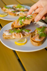 Summer outdoor reception, salmon toast with dill and dill sauce, eating starters in sun