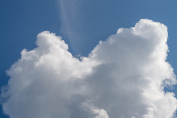 Fluffy white clouds drift peacefully against a bright blue sky on a lovely day outside
