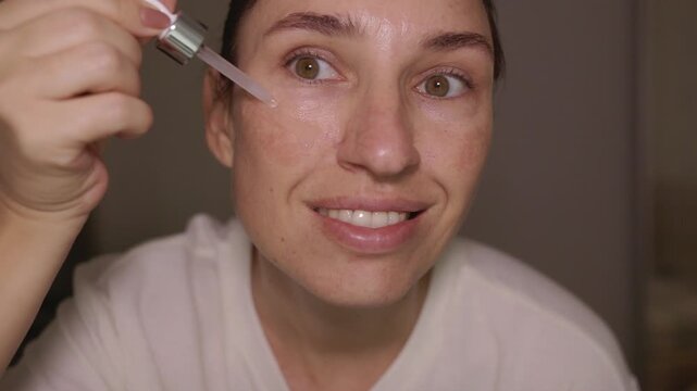 Woman using dermapen on face, cheeks, forehead and around the mouth. Female with pigmentation spots and rosacea taking care of her skin at home. Concept of skincare and facial rejuvenation.