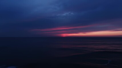 Ocean Waves Gently Reaching Shore at Dramatic Pink and Purple Sunset