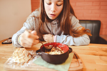 Young girl enjoying homemade cr&egrave;me br&ucirc;l&eacute;e with a scoop of ice cream and whipped cream