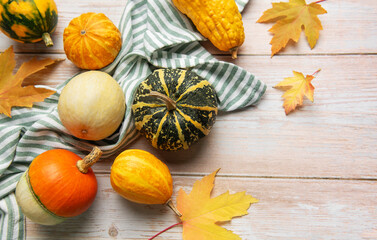 Autumn gourds pumpkins and fall leaves on wooden background