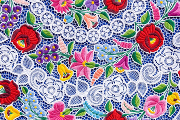Close-up of colorful Richelieu embroidery tablecloth in natural light.