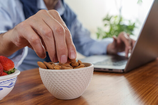 Enjoying a healthy snack while working at home with laptops and fresh fruits on the table