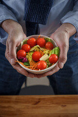 Closeup of hands holding salad bowl