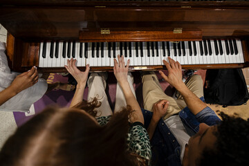 Group of musicians playing piano together in collaborative setting