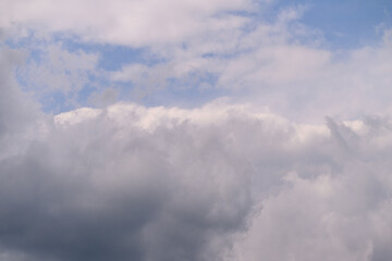 A stunning and beautiful skyscape featuring fluffy white clouds against a clear blue background