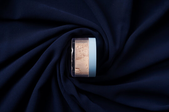 A Wardah powder sits elegantly on a navy-colored fabric