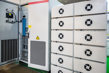 Industrial electrical cabinet with intricate wiring and components revealed, next to modular server units with cooling fans. Depicting advanced technology, power distribution, and data center infrastr