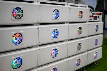 A row of modern modular battery units or servers featuring colorful LED-lit cooling fans, highlighting advanced technology and energy solutions. Ideal for concepts of power, data, and innovation.