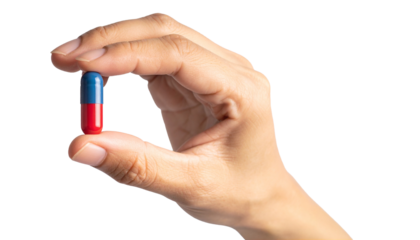 A hand holding a blue and red pill, symbolizing medicine and healthcare
