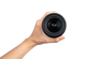 Close-up of a hand holding a camera lens, showcasing the precision and focus of photography.