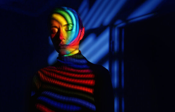 Surreal portrait with neon spiral projection and closed eyes