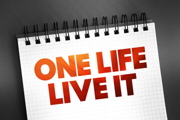 One Life Live It text on notepad, concept background