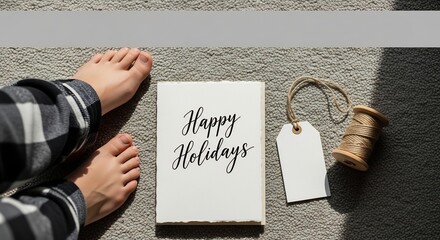 Image shows feet card with Happy Holidays spool tag on rug partially shaded