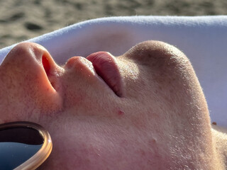 Closeup of person sunbathing with relaxed face