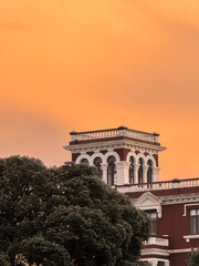 Historic tower rising above trees at sunset sky